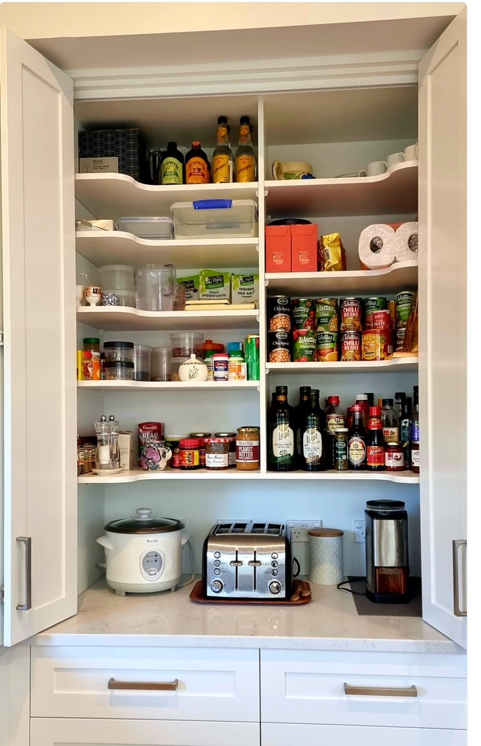 A kitchen pantry filled with lots of food and appliances.