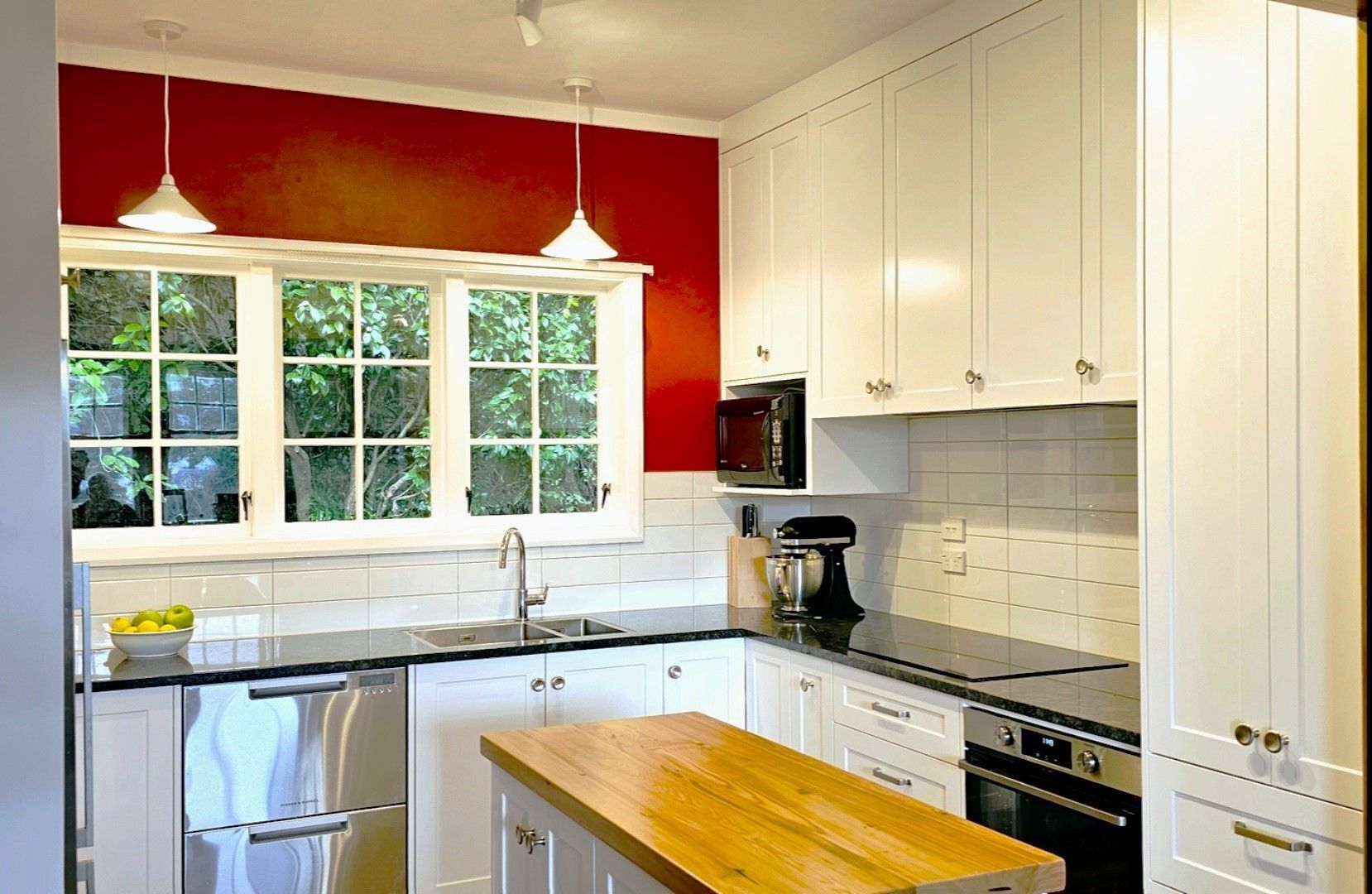 A kitchen with white cabinets and stainless steel appliances