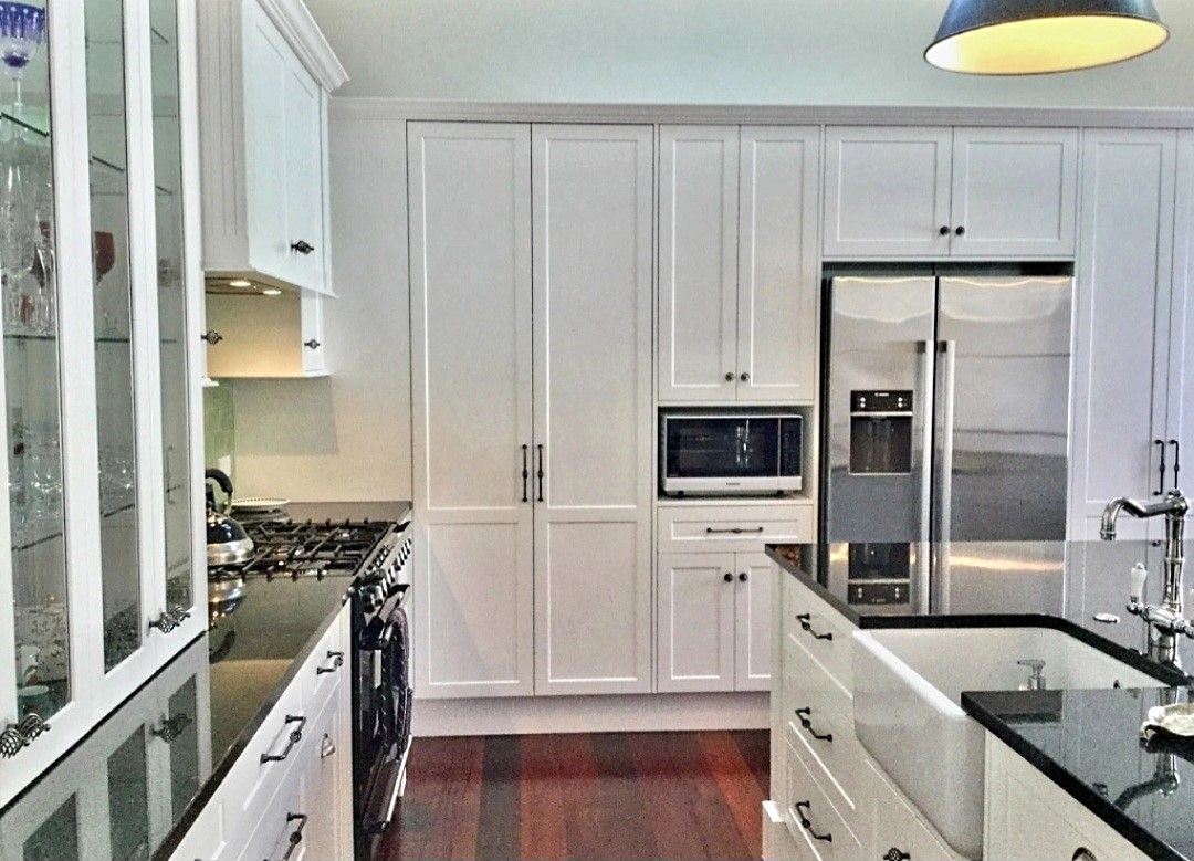 A kitchen with white cabinets and stainless steel appliances