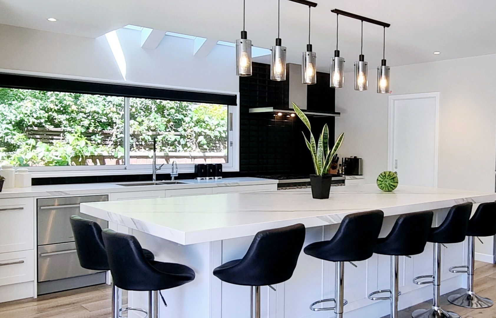 A kitchen with a large island and black chairs