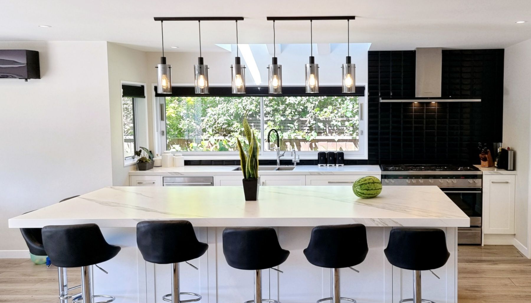 A kitchen with a large island and black stools