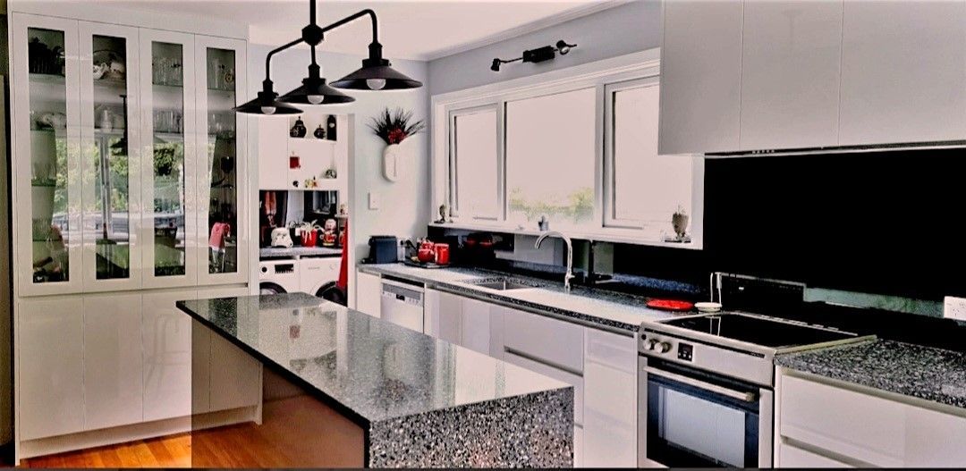 A kitchen with white cabinets and granite counter tops.