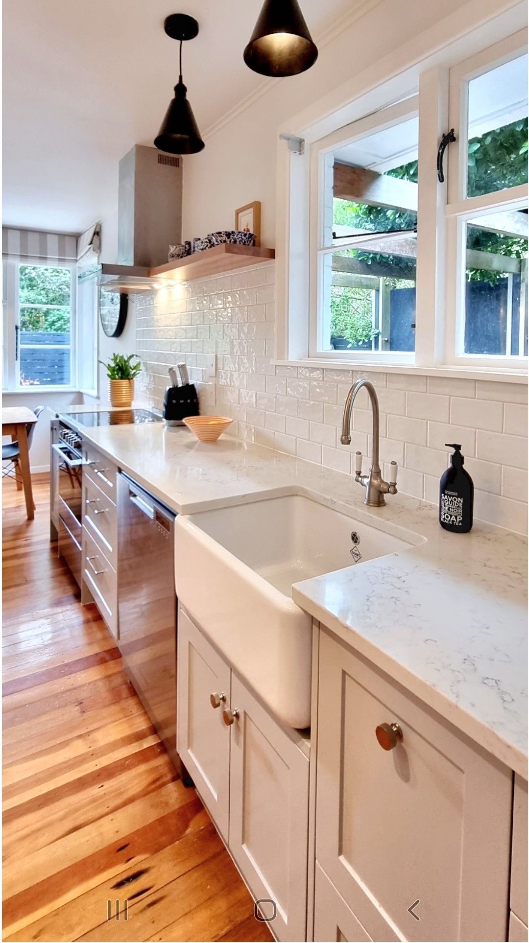 A kitchen with white cabinets and a white sink