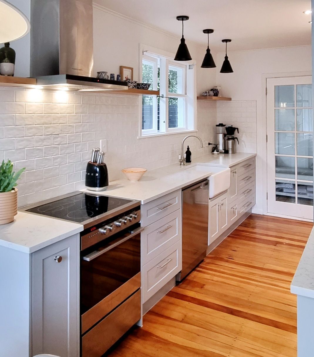 A kitchen with stainless steel appliances and wooden floors