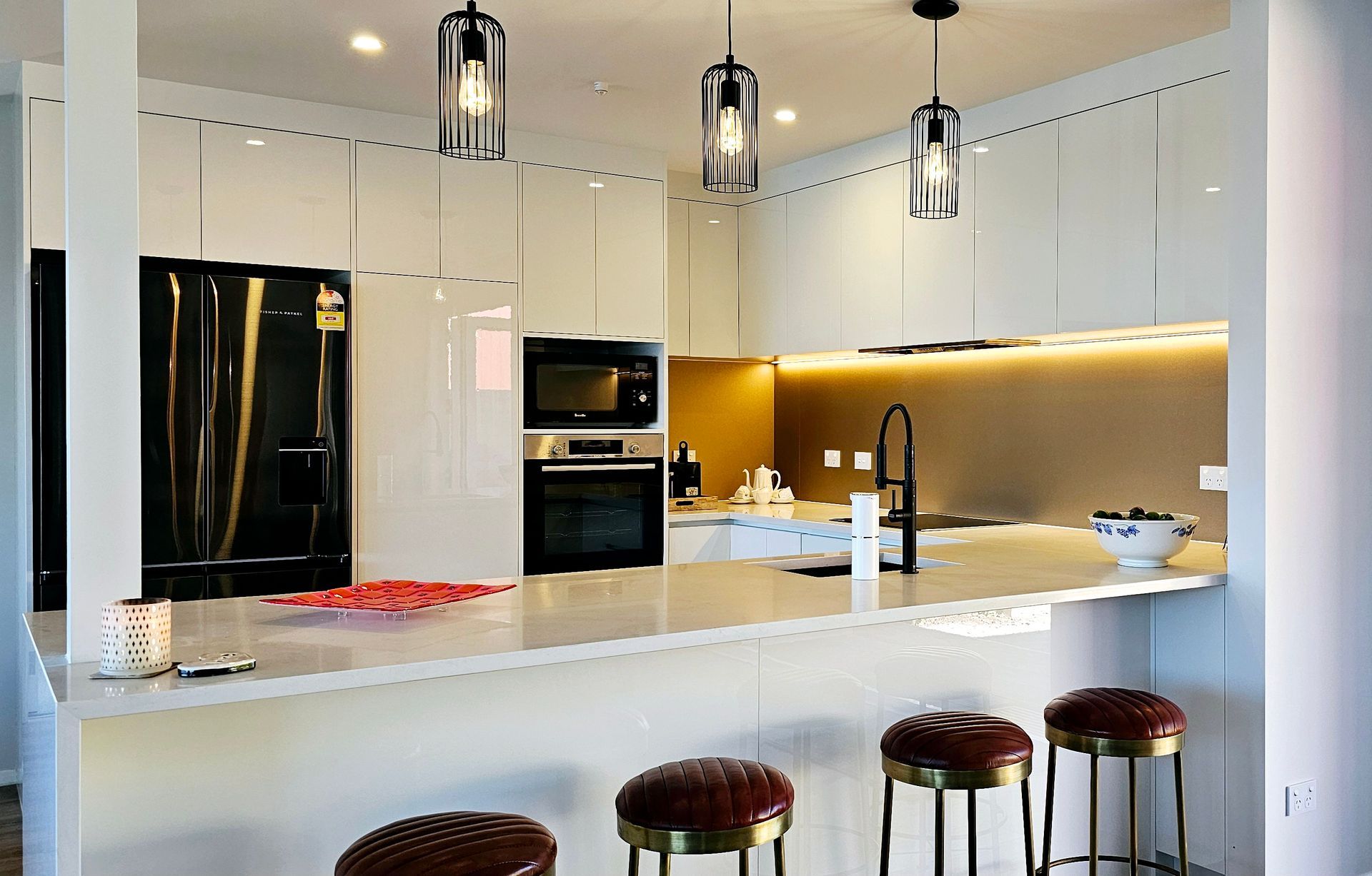 A kitchen with white cabinets and a black refrigerator