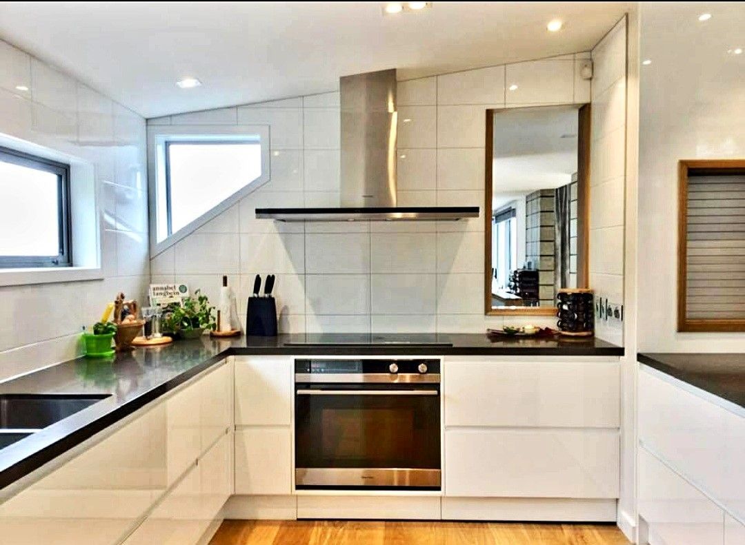 A kitchen with white cabinets and black counter tops