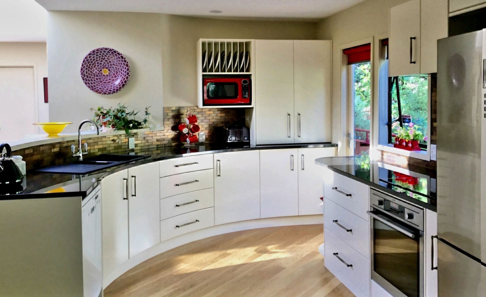 A kitchen with curved cabinets and stainless steel appliances