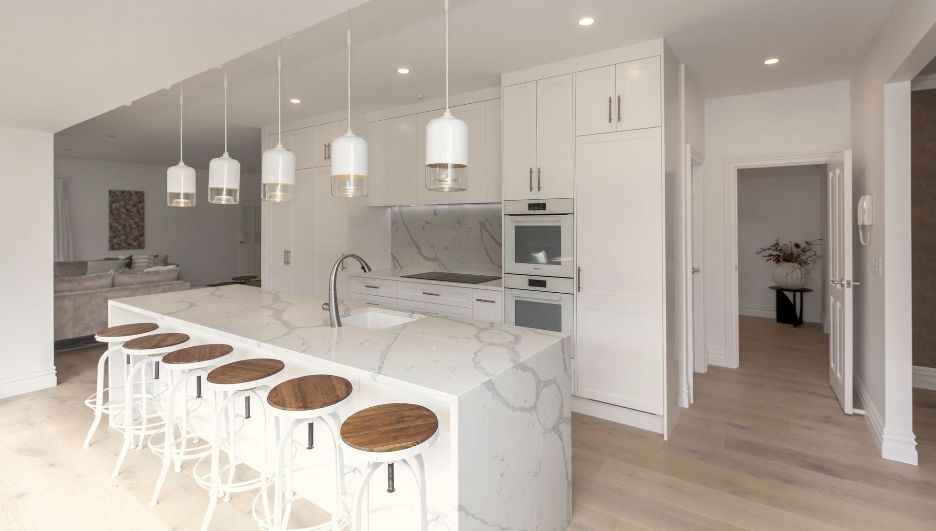 An artist 's impression of a kitchen with a large island and stools.