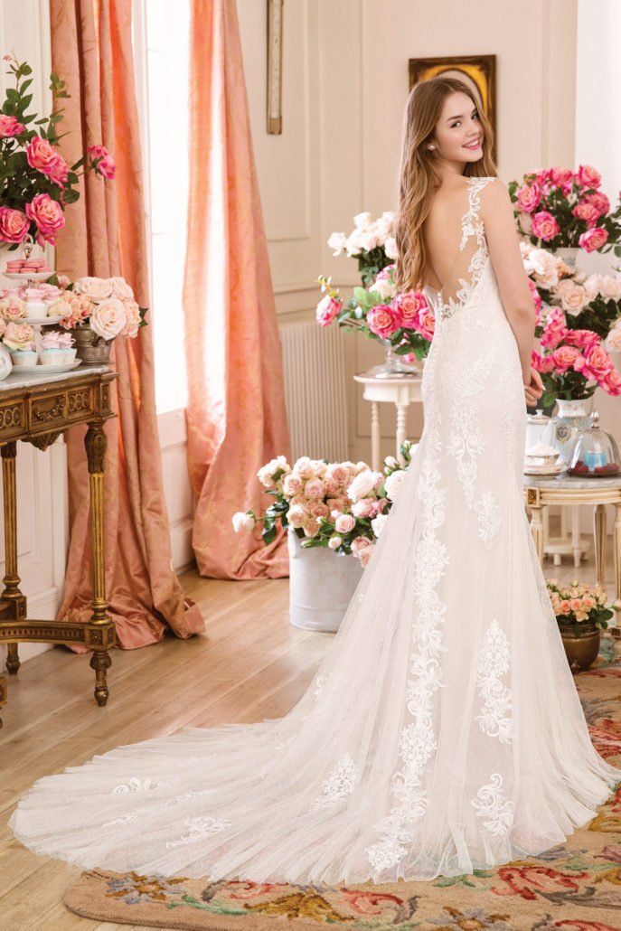 Eine Frau in einem Brautkleid steht in einem Raum mit Blumen.