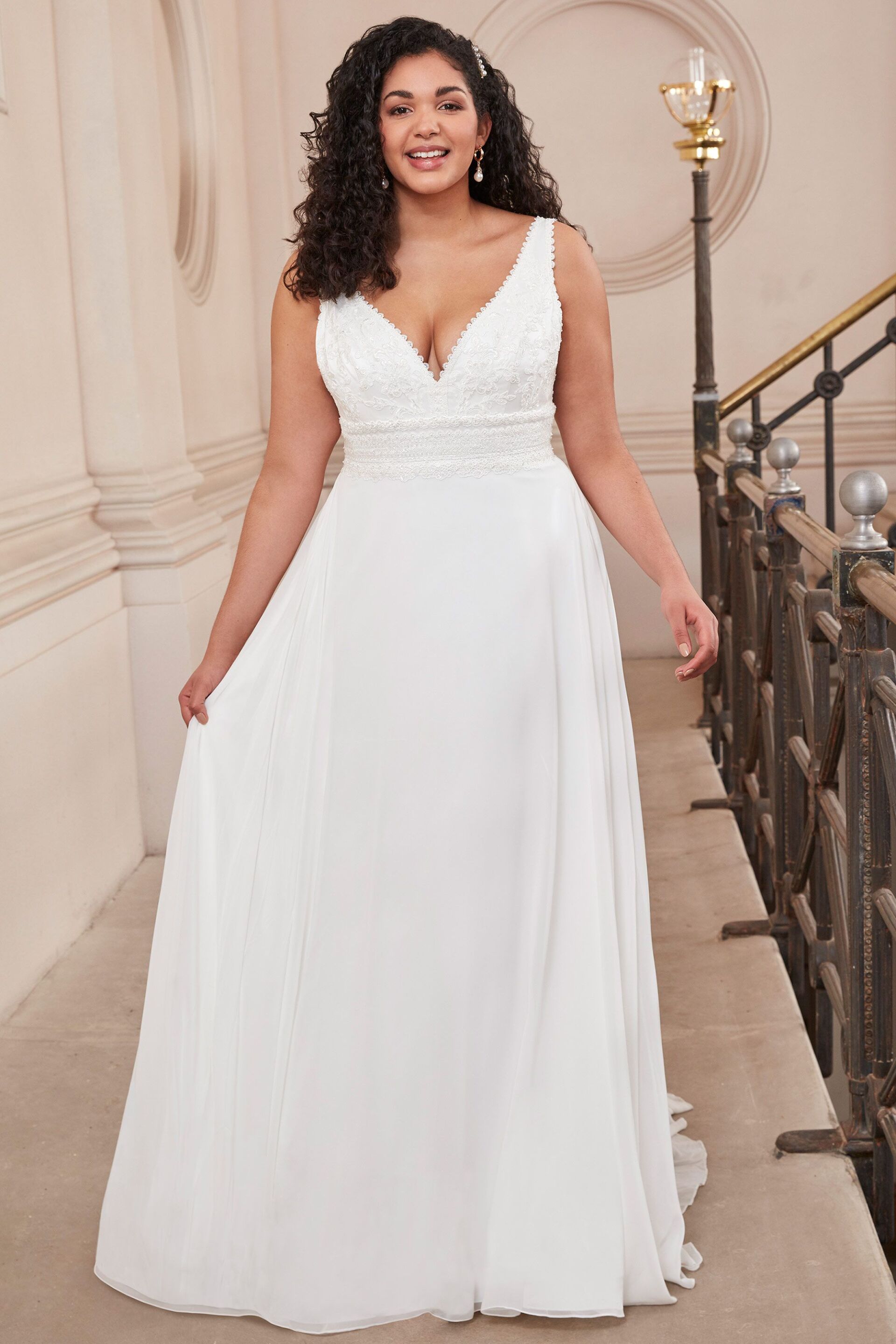 Eine Frau mit Übergröße trägt ein weißes Hochzeitskleid.