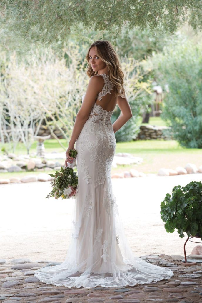 Eine Frau in einem Brautkleid hält einen Blumenstrauß.