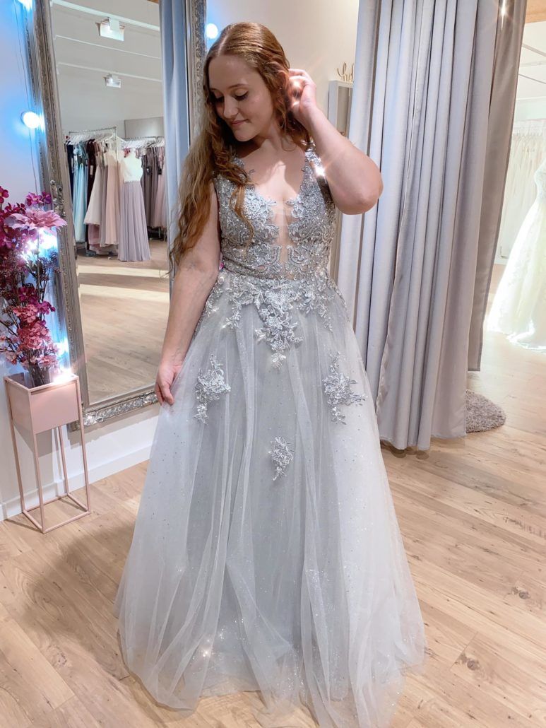 Eine Frau probiert vor einem Spiegel ein Kleid an.