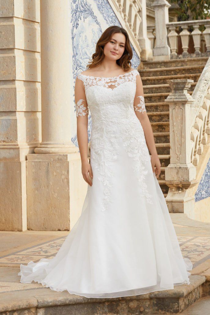 Eine Frau in einem weißen Brautkleid steht auf einer Treppe.