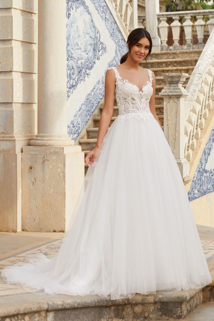 Eine Frau in einem weißen Brautkleid steht auf einer Treppe.