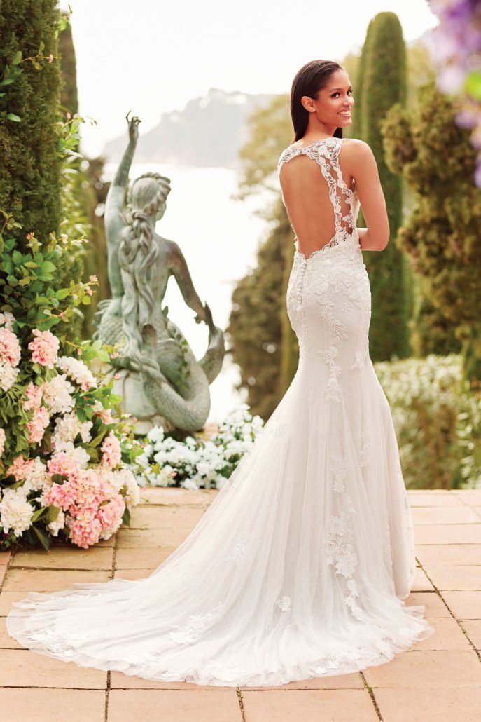 Eine Frau in einem Hochzeitskleid steht vor einer Statue.