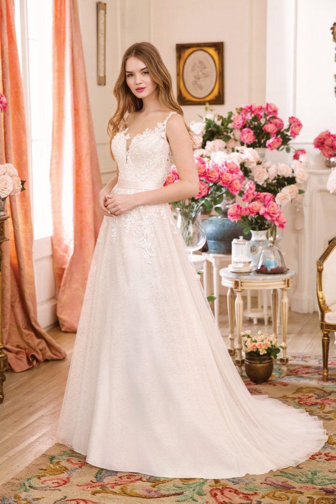 Eine Frau in einem Brautkleid steht in einem Raum mit Blumen.