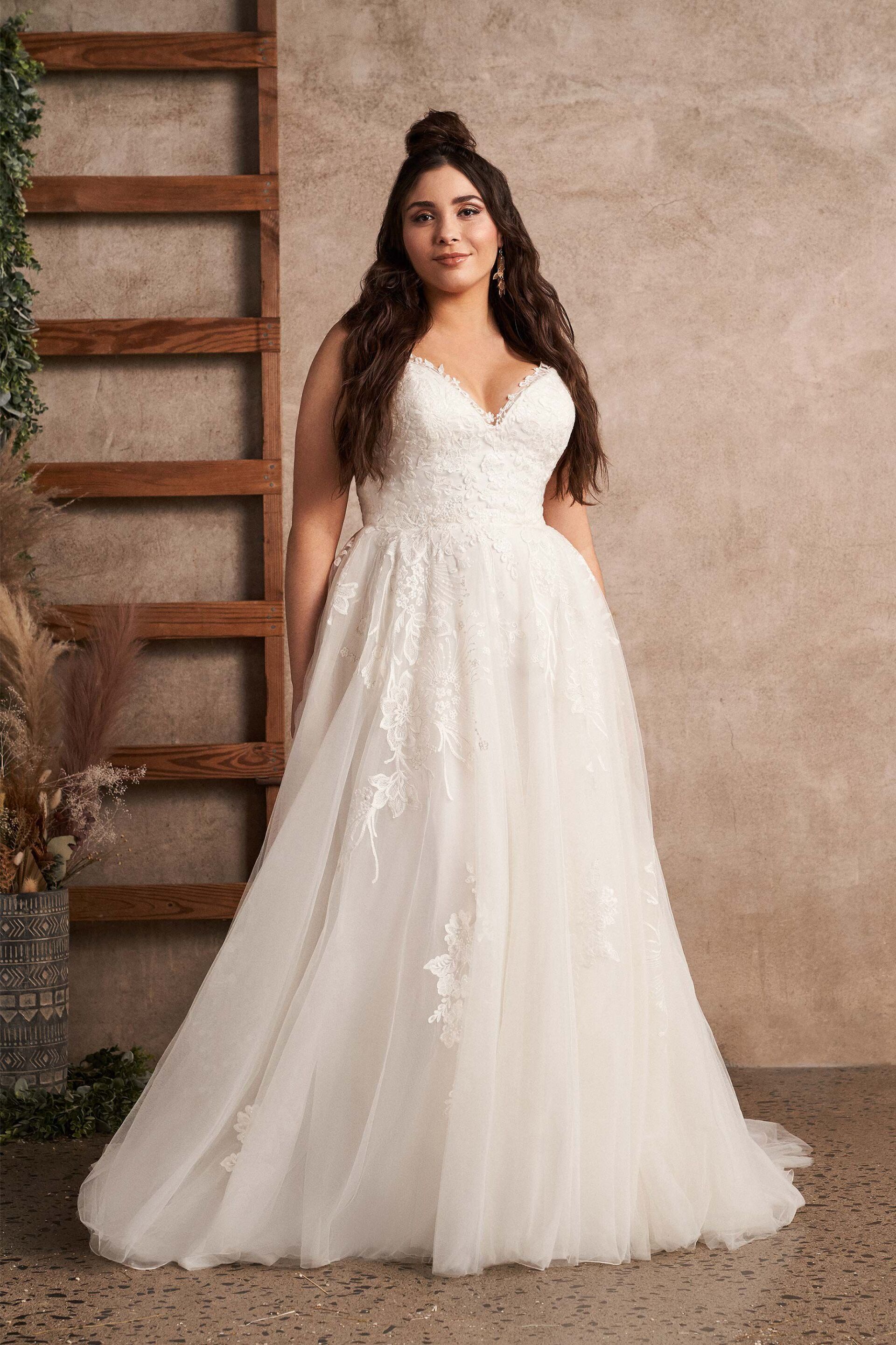 Eine Frau mit Übergröße trägt ein weißes Hochzeitskleid.