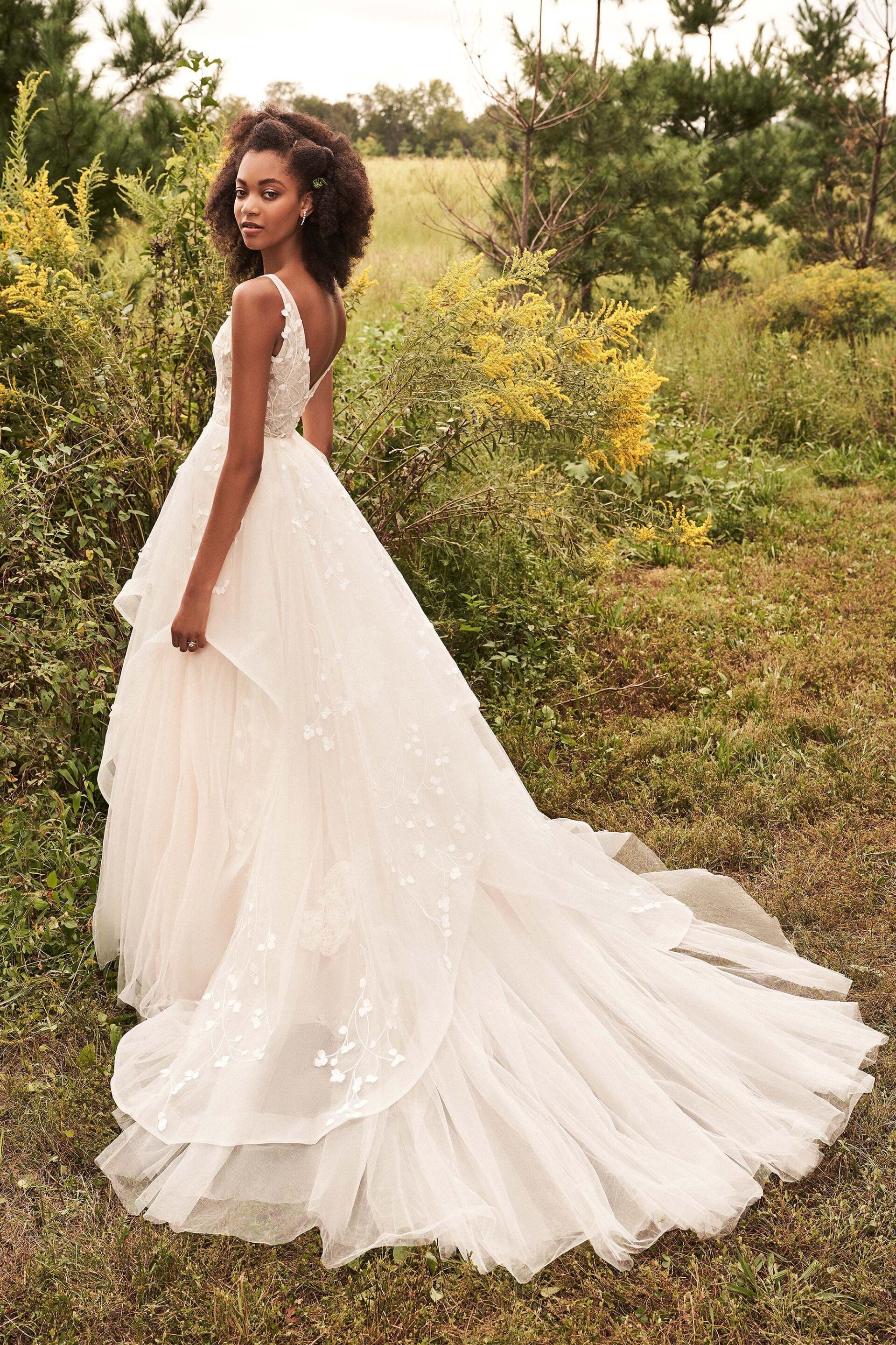 Eine Frau in einem Brautkleid steht auf einem Feld.