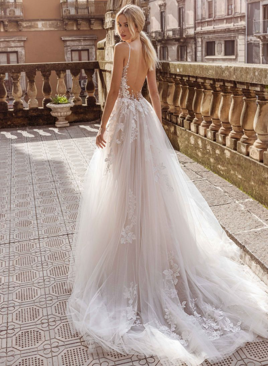 Eine Frau in einem Brautkleid steht auf einem Balkon.