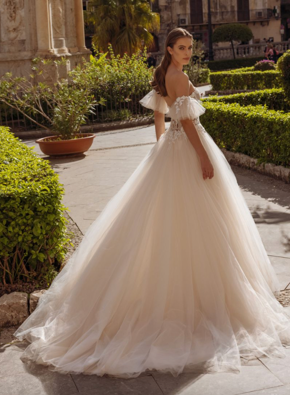 Eine Frau in einem Brautkleid steht auf einem Bürgersteig.