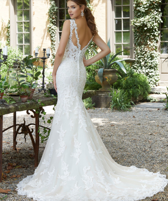 Eine Frau in einem Brautkleid steht in einem Garten