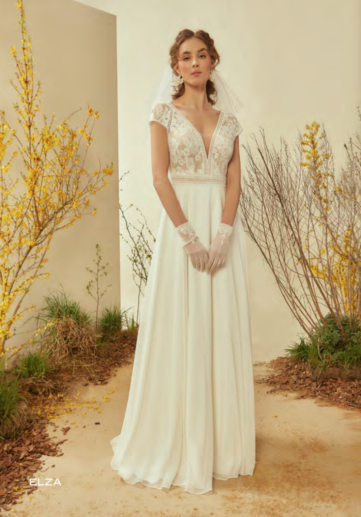 Eine Frau trägt ein weißes Hochzeitskleid und Handschuhe.