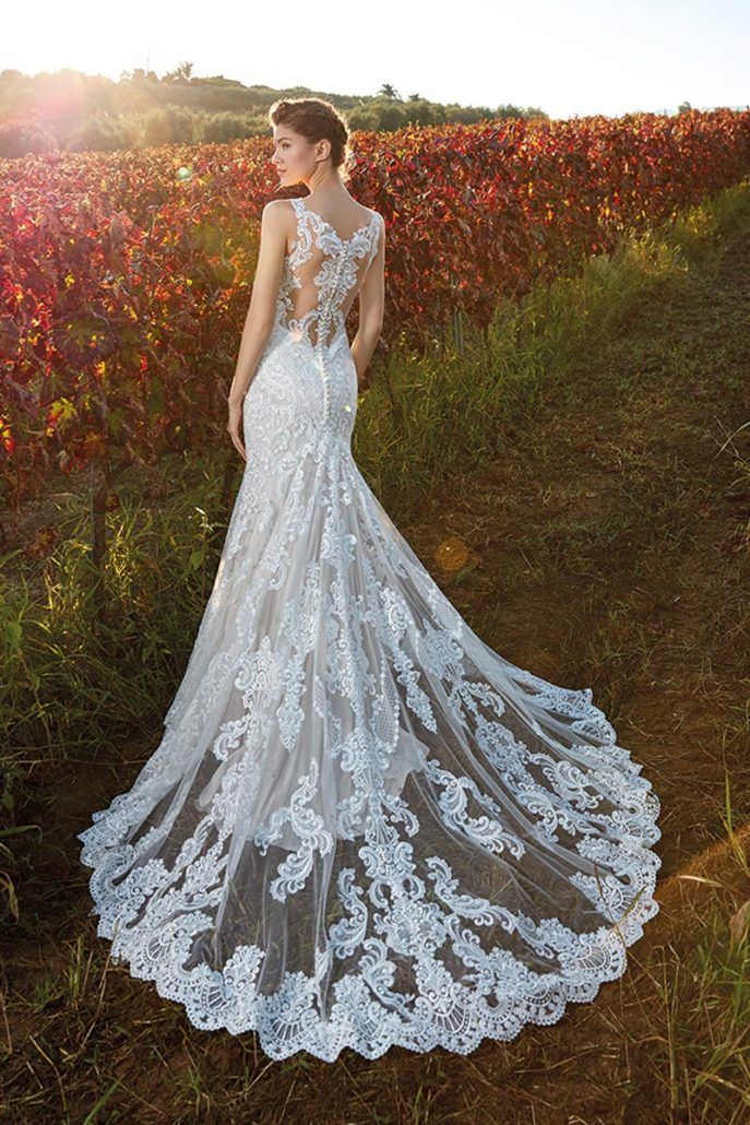 Eine Frau in einem Hochzeitskleid steht in einem Blumenfeld.