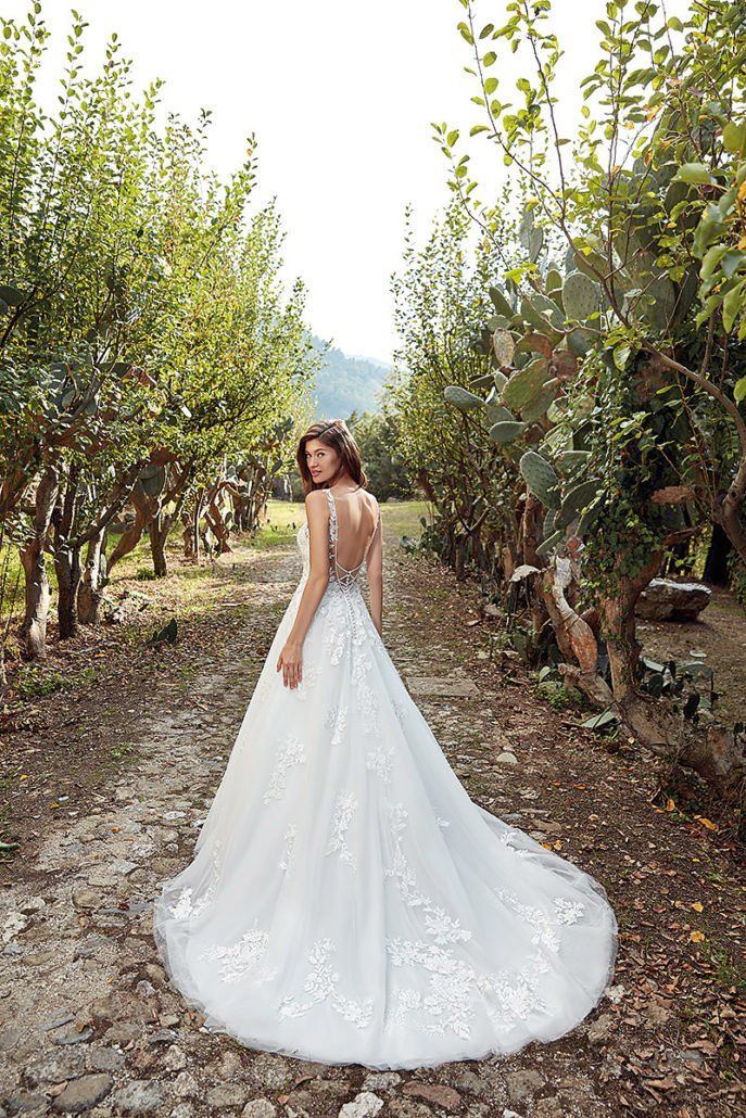 Eine Frau in einem weißen Brautkleid steht in einem Wald.
