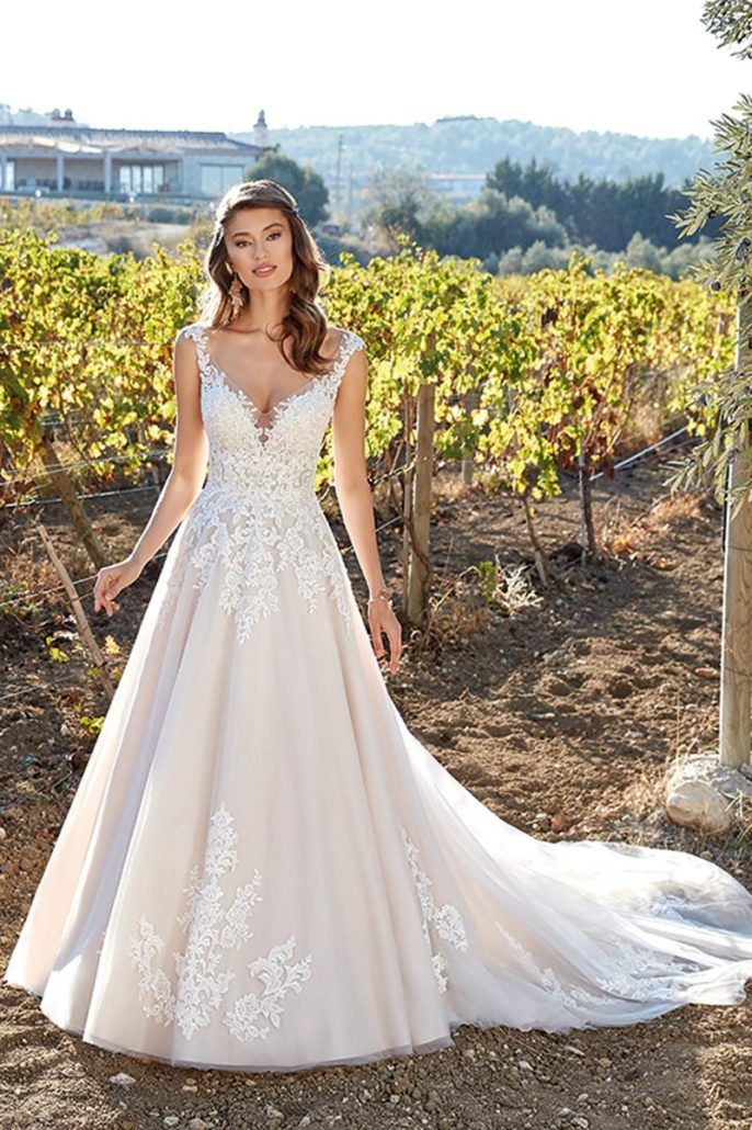 Eine Frau in einem Brautkleid steht auf einem Feld.