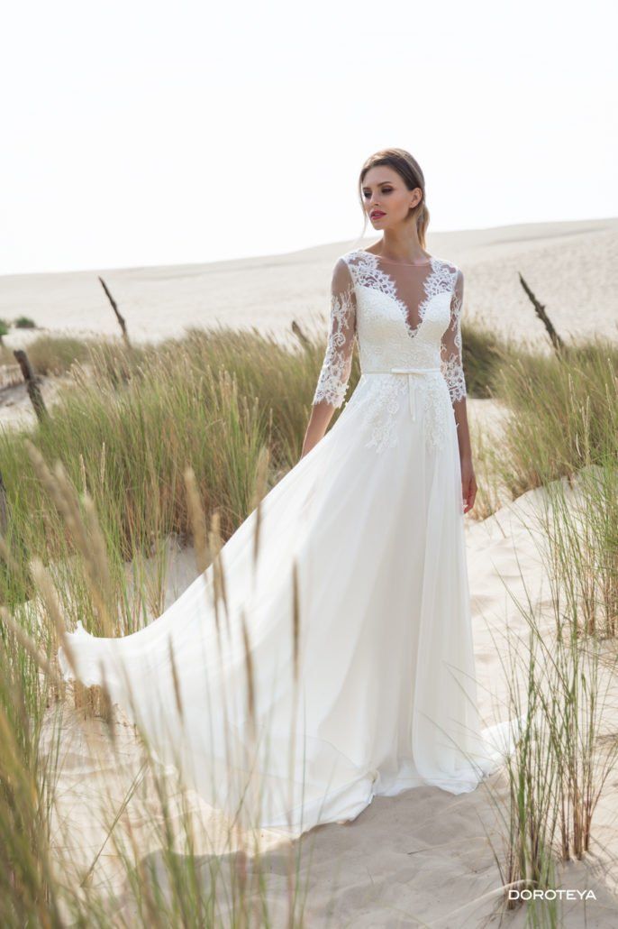 Eine Frau in einem weißen Hochzeitskleid steht mitten auf einem Feld.