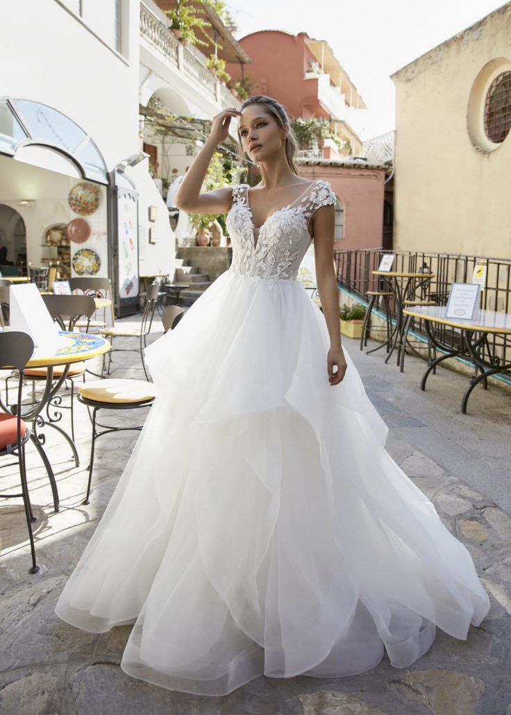 Eine Frau in einem weißen Brautkleid steht vor einem Restaurant.