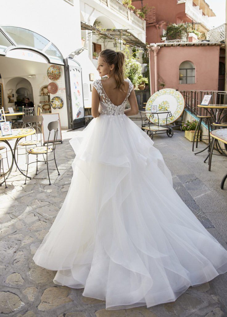 Eine Frau in einem weißen Brautkleid steht vor einem Restaurant.