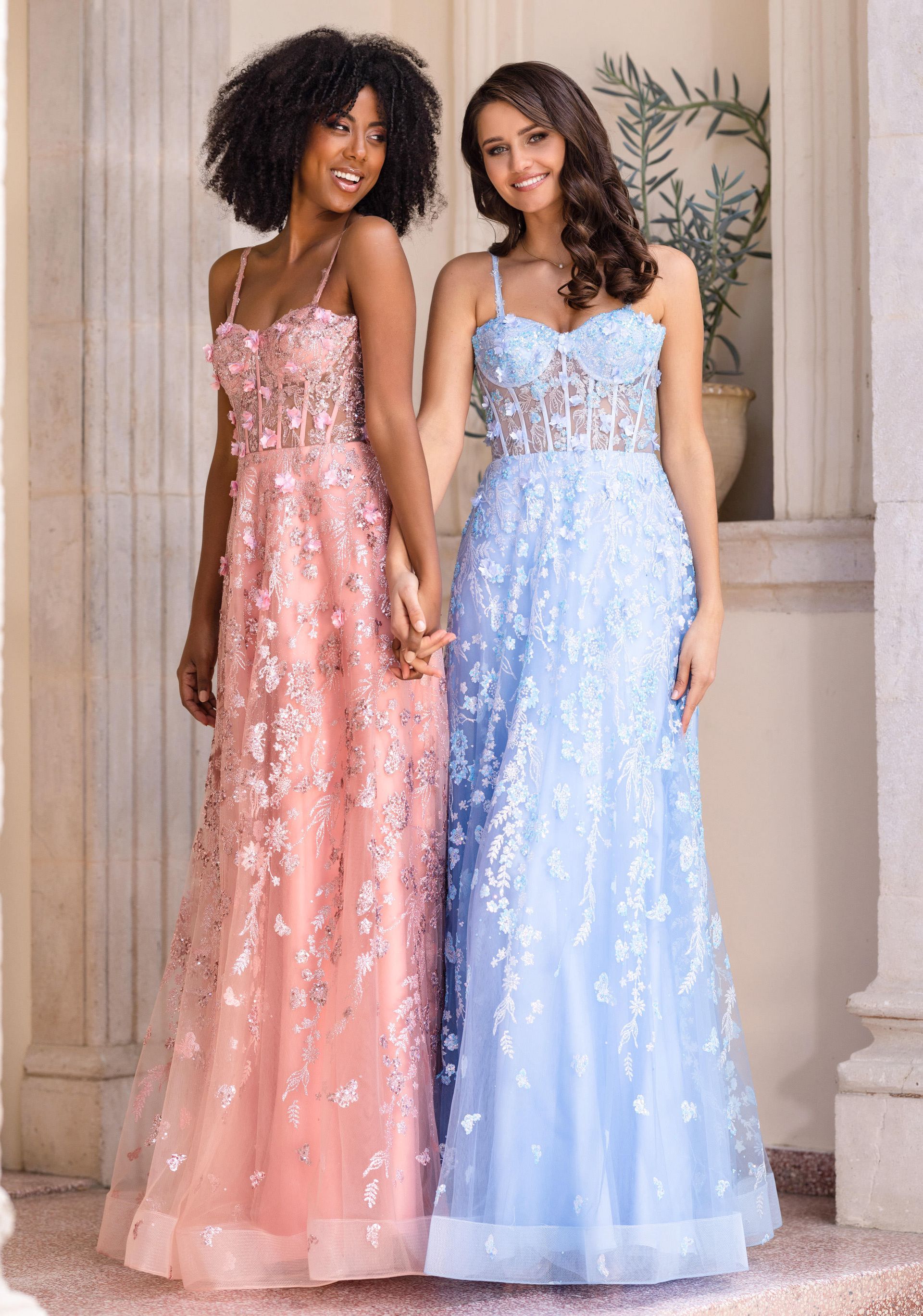 Zwei Frauen in Ballkleidern stehen nebeneinander.