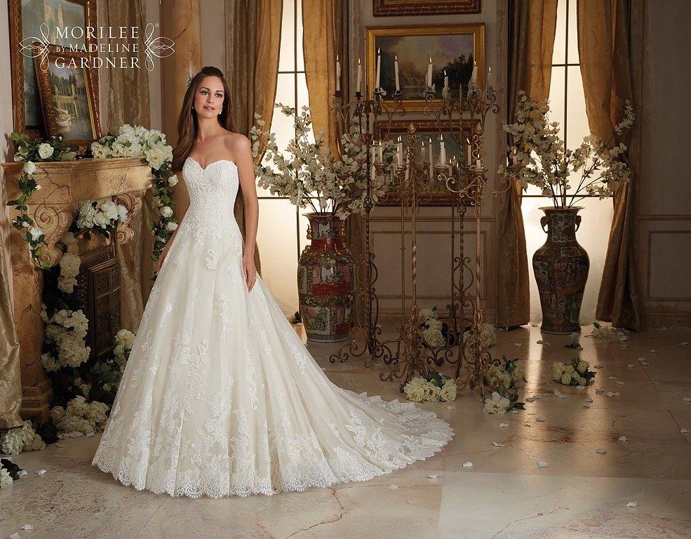 Eine Frau in einem Brautkleid steht in einem Raum mit Blumen.