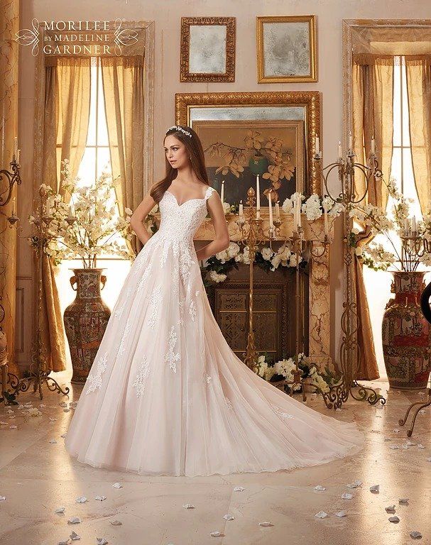 Eine Frau in einem Brautkleid steht in einem Zimmer vor einem Kamin.