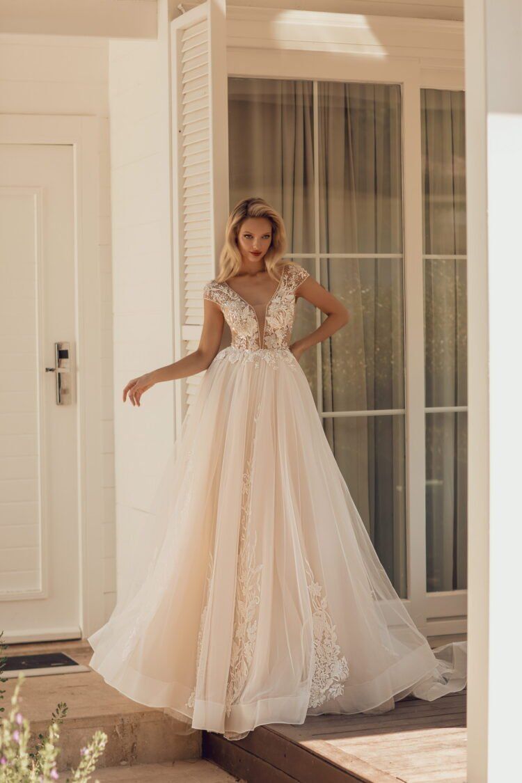 Eine Frau in einem Brautkleid steht vor einer Tür.