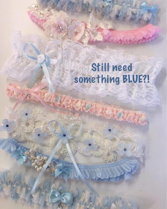 Ein Haufen Strumpfbänder ist übereinander gestapelt und trägt die Aufschrift „Brauche noch etwas Blaues“.