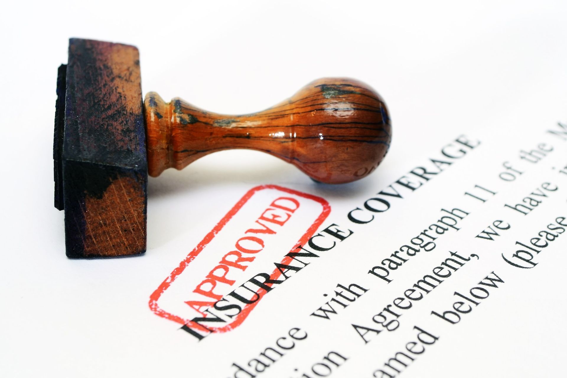 A brown wood handle stamp lies on top of a white piece of paper labeled 