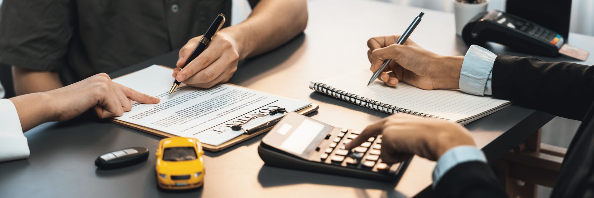 Two professionals calculate auto insurance rates.