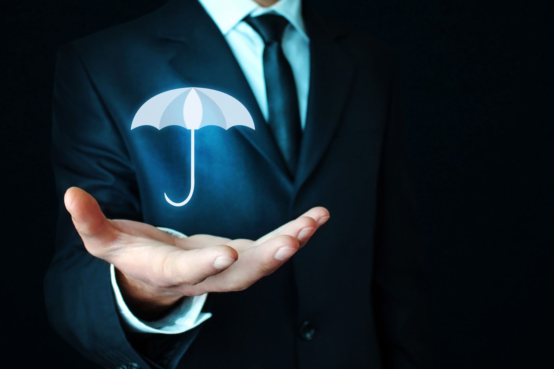 A man wearing a suit holds out his hand. A blue graphic of an umbrella hovers over his hand.