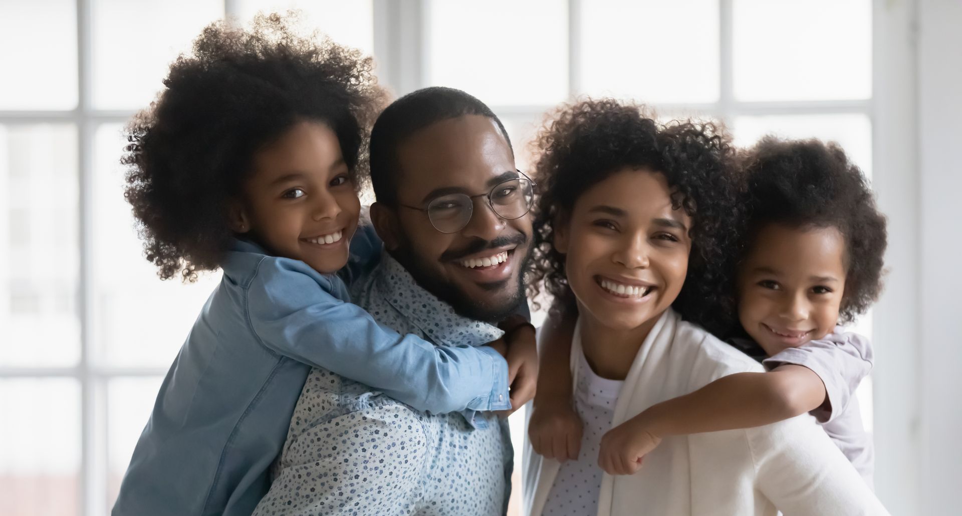 African American family of 4 poses for the camera, they are weighing the benefits and disadvantages to fully insured vs self insured