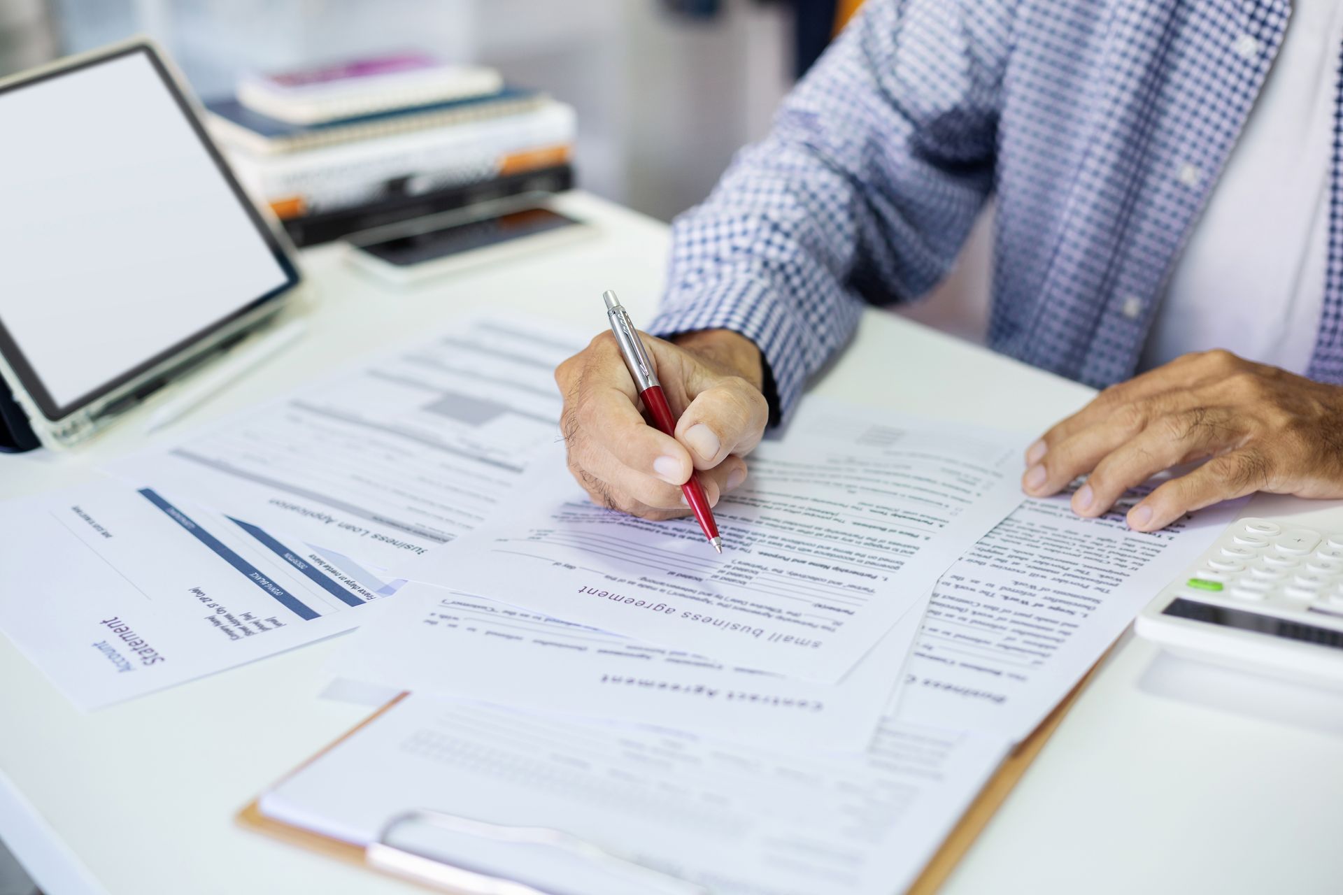 A man is sitting at a desk filling out workers' compensation exemption paperwork