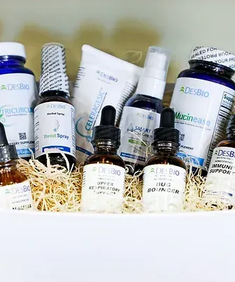 A variety of bottles and containers are sitting on top of a pile of hay.