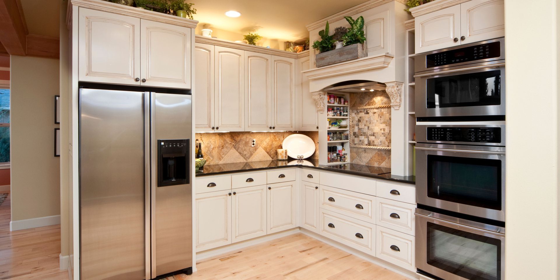 A kitchen with stainless steel appliances and white cabinets.