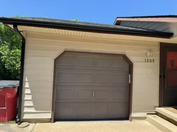 1 car garage closed door with gutter and downspout around the fram