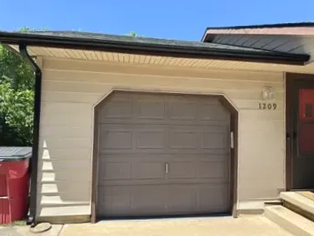 1 car garage closed door with gutter and downspout around the frame