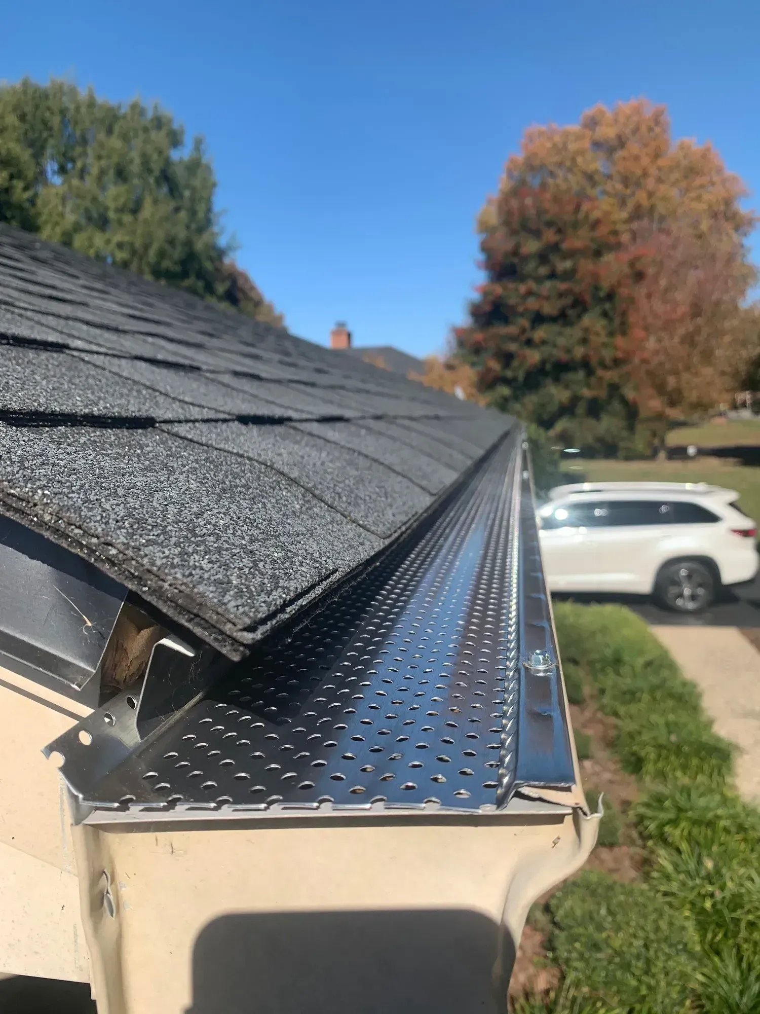 House showing gutter guard protection attached to fascia of home with ceramic shingles