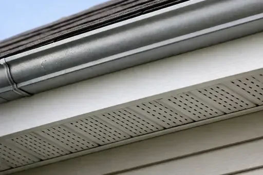 Close-up of a Wichita home roof edge showing the fascia board behind the gutter and the vented soffit underneath