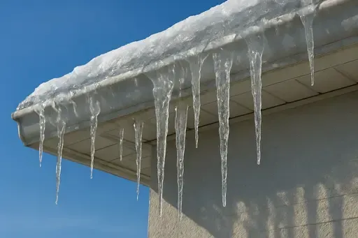 Ice dam formation on Wichita Kansas home showing water backup and gutter repair needs