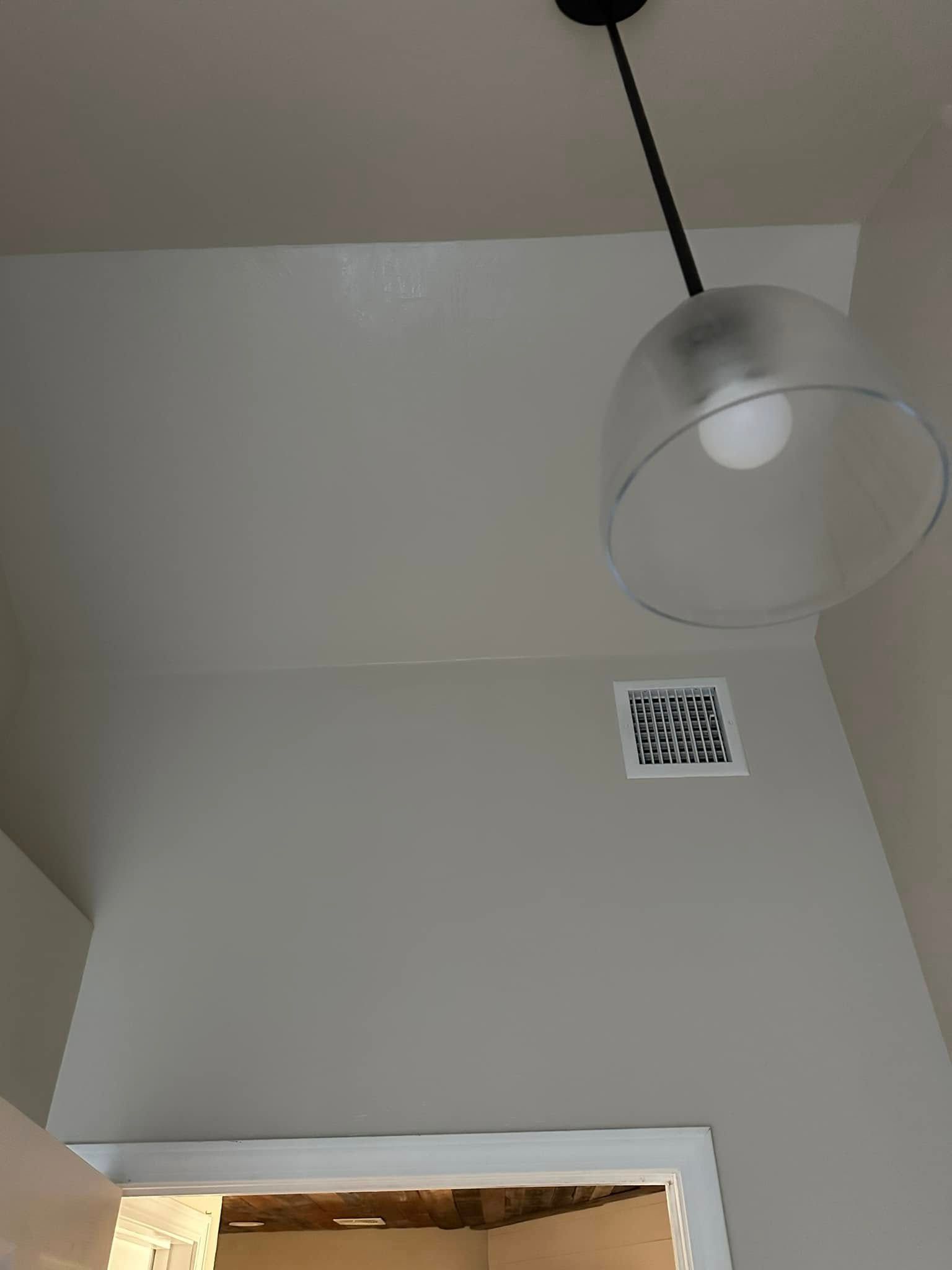 A light fixture is hanging from the ceiling in a room.